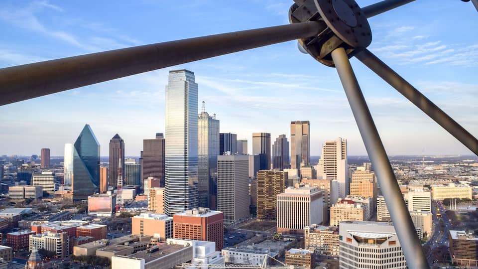 A cityscape with a prominent skyscraper and a distinctive twisted building.
