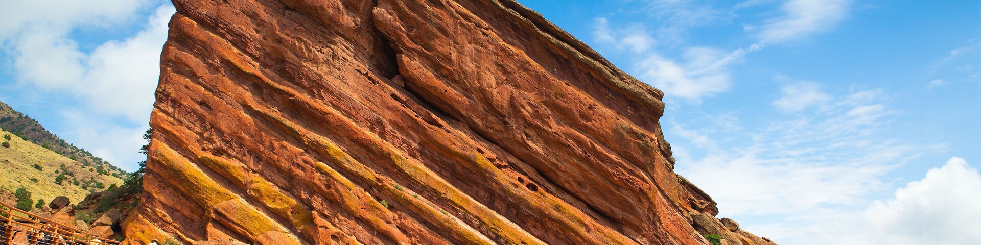 A large red rock formation with a set of outdoor amphitheater steps.
