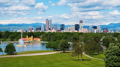 A city skyline with a lake, park, and mountains in the background.