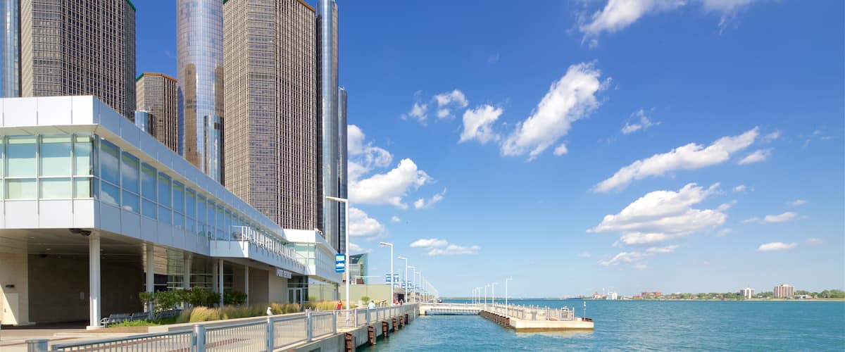 A waterfront with modern buildings, a bridge, and a clear blue sky.