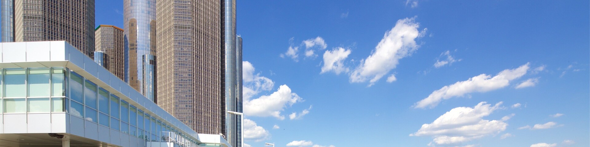 A waterfront with modern buildings, a bridge, and a clear blue sky.