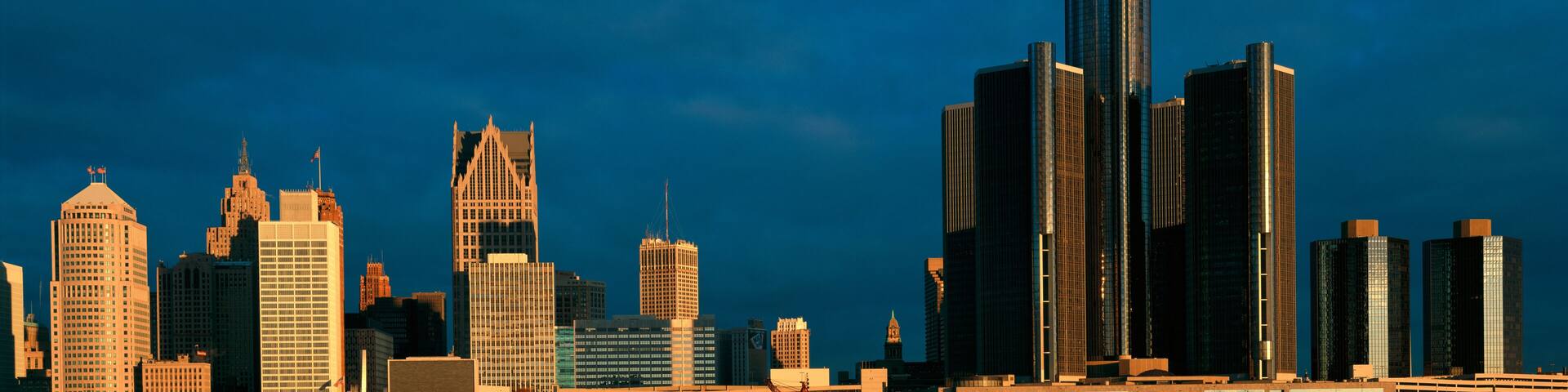 A city skyline with a mix of modern and historic buildings under a clear sky.