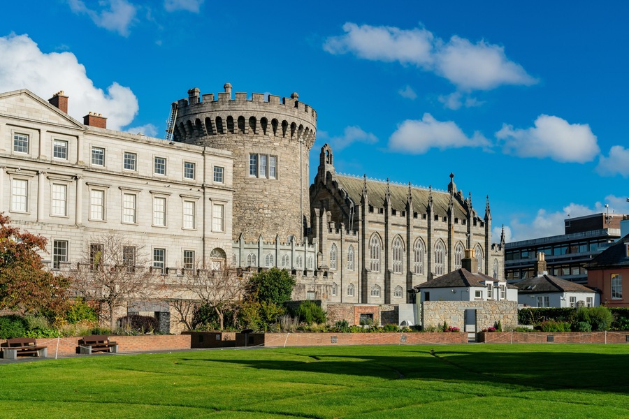 Um castelo histórico com uma torre redonda e um edifício grande com janelas em arco.