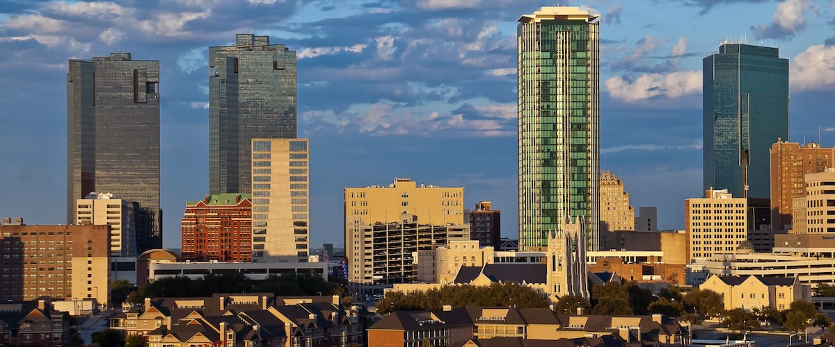 A city skyline with modern skyscrapers and residential houses.