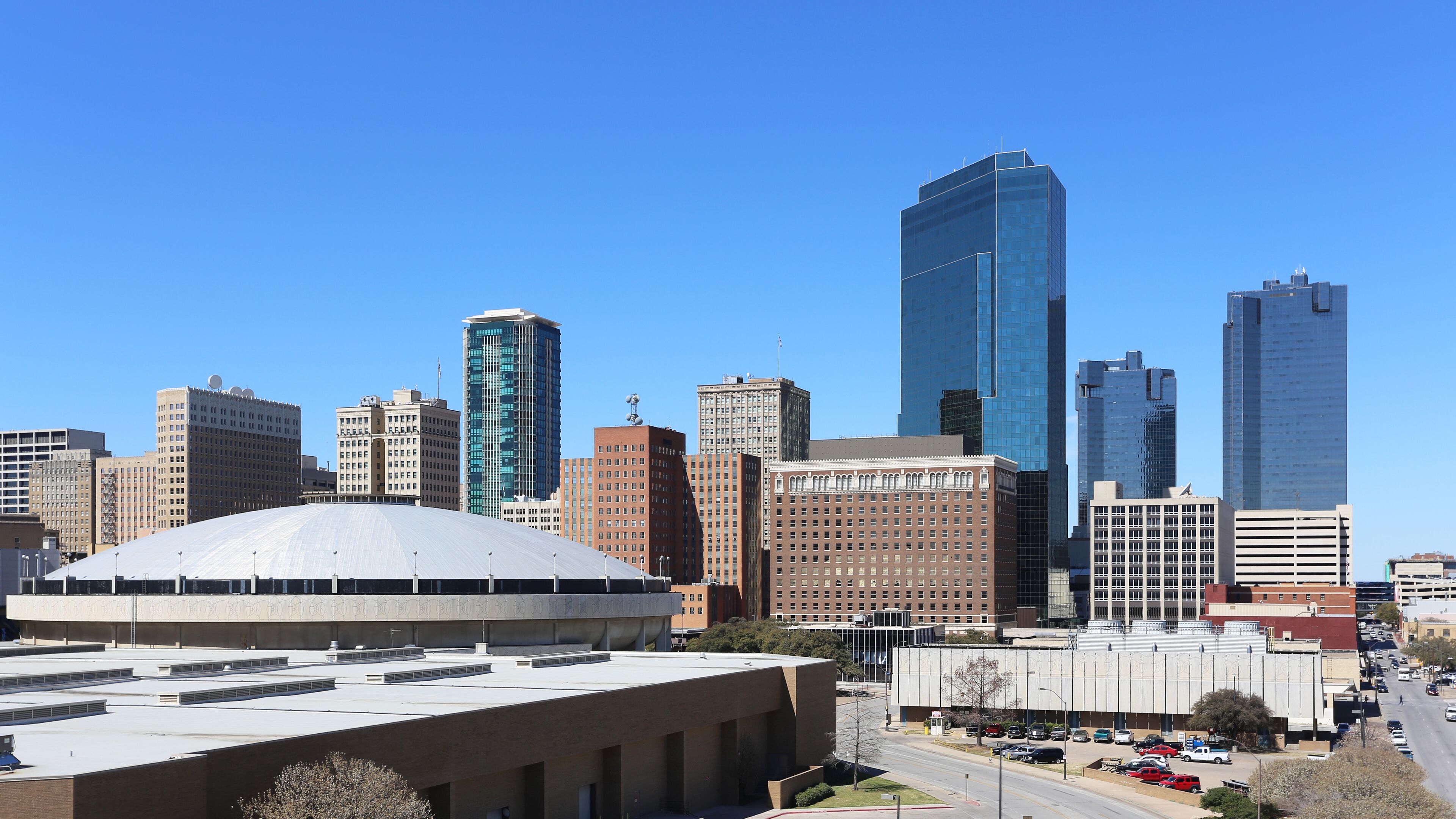 A city skyline with modern skyscrapers and a large dome structure.