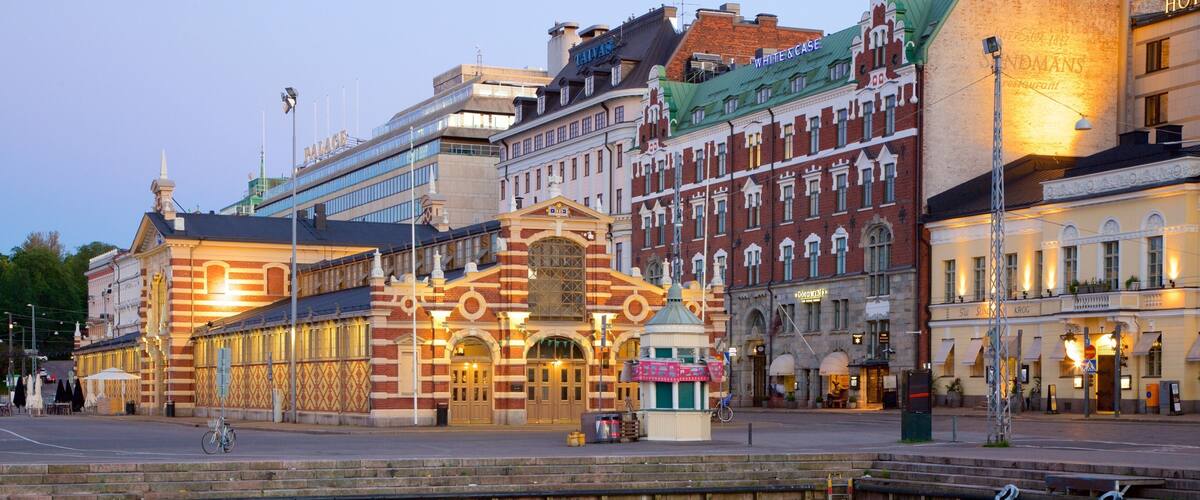 A historic building with a distinctive facade, a canal in the foreground, and various commercial establishments in the background.