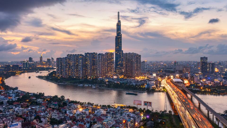 A cityscape with a prominent skyscraper, a river, and a bridge.