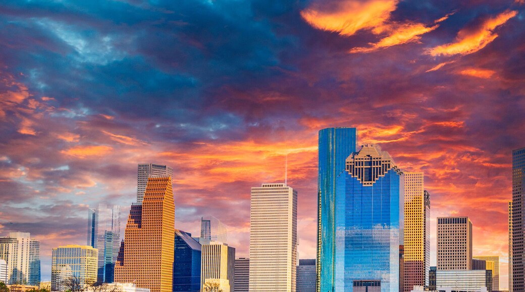 Houston Texas downtown buildings and city skyline, panoramic metropolis landscape with dramatic clouds over the public park at sunset