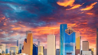 Houston Texas downtown buildings and city skyline, panoramic metropolis landscape with dramatic clouds over the public park at sunset