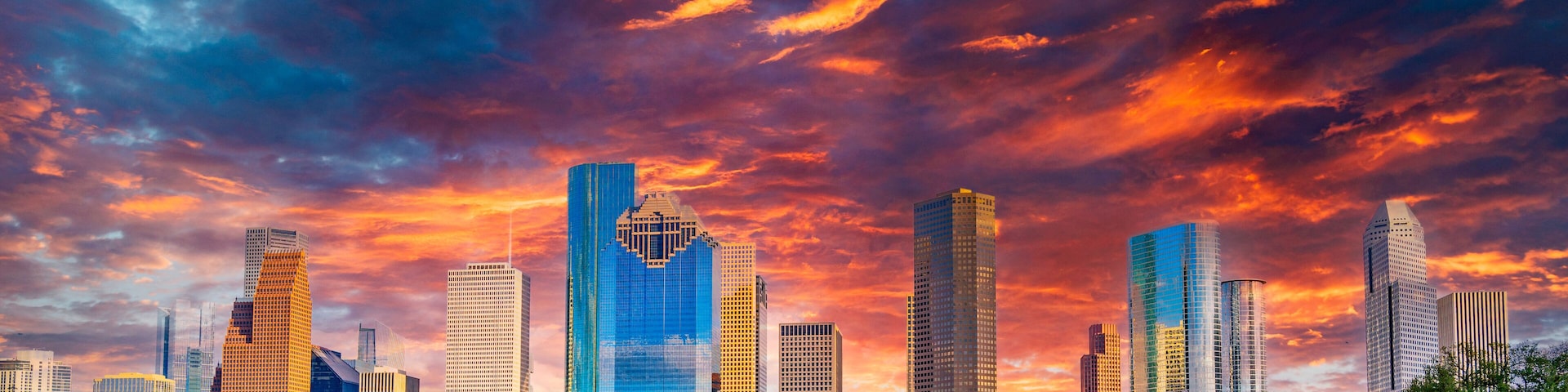 Houston Texas downtown buildings and city skyline, panoramic metropolis landscape with dramatic clouds over the public park at sunset