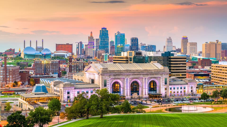 A city skyline with a prominent historic building in the foreground and modern skyscrapers in the background.