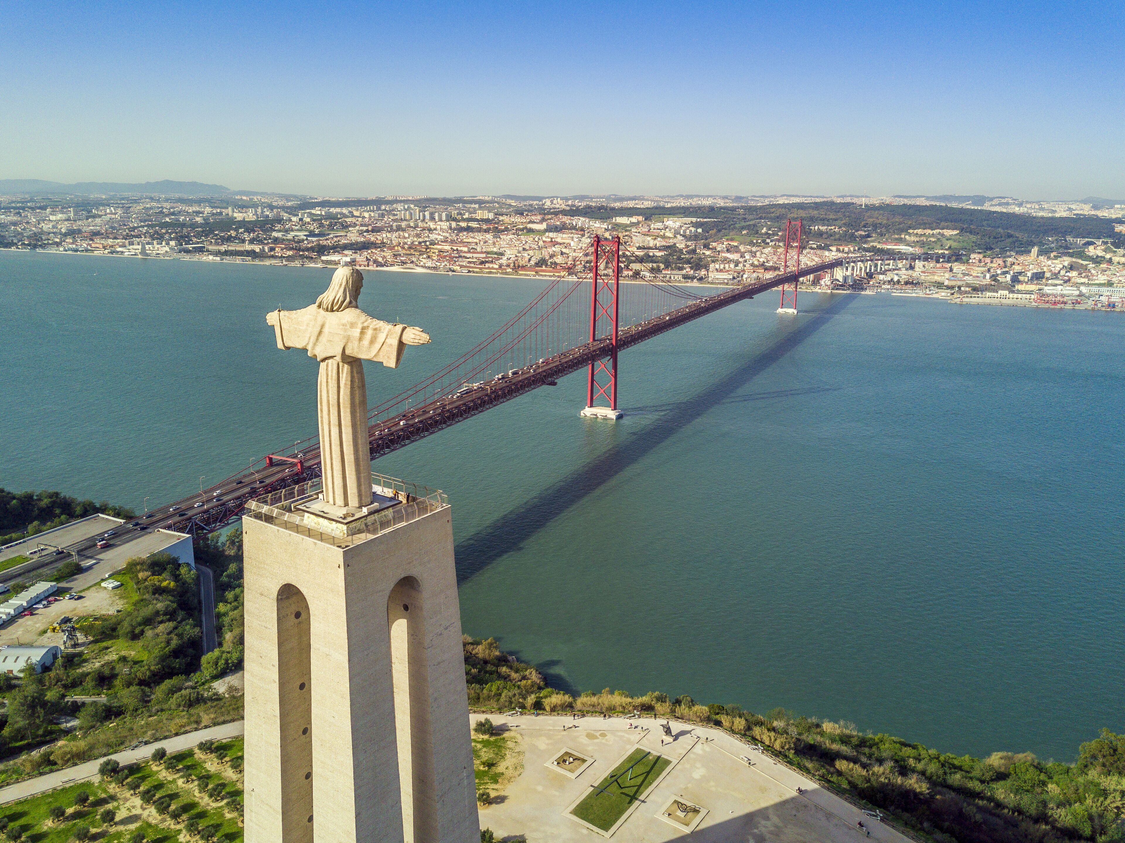 A large statue overlooking a bridge spanning a body of water.