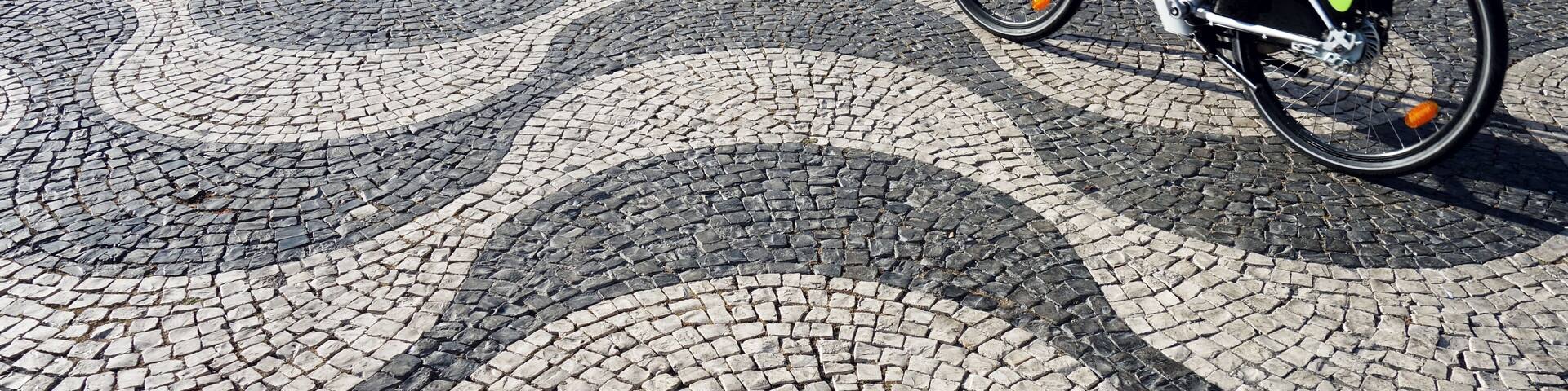 Bicycle on Lisbon pavement pavement (Calçada portuguesa) in Lisbon, Portugal. Praça Dom Pedro IV.