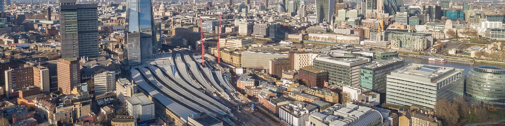 A cityscape with the Shard, a large modern skyscraper, and a complex railway station.