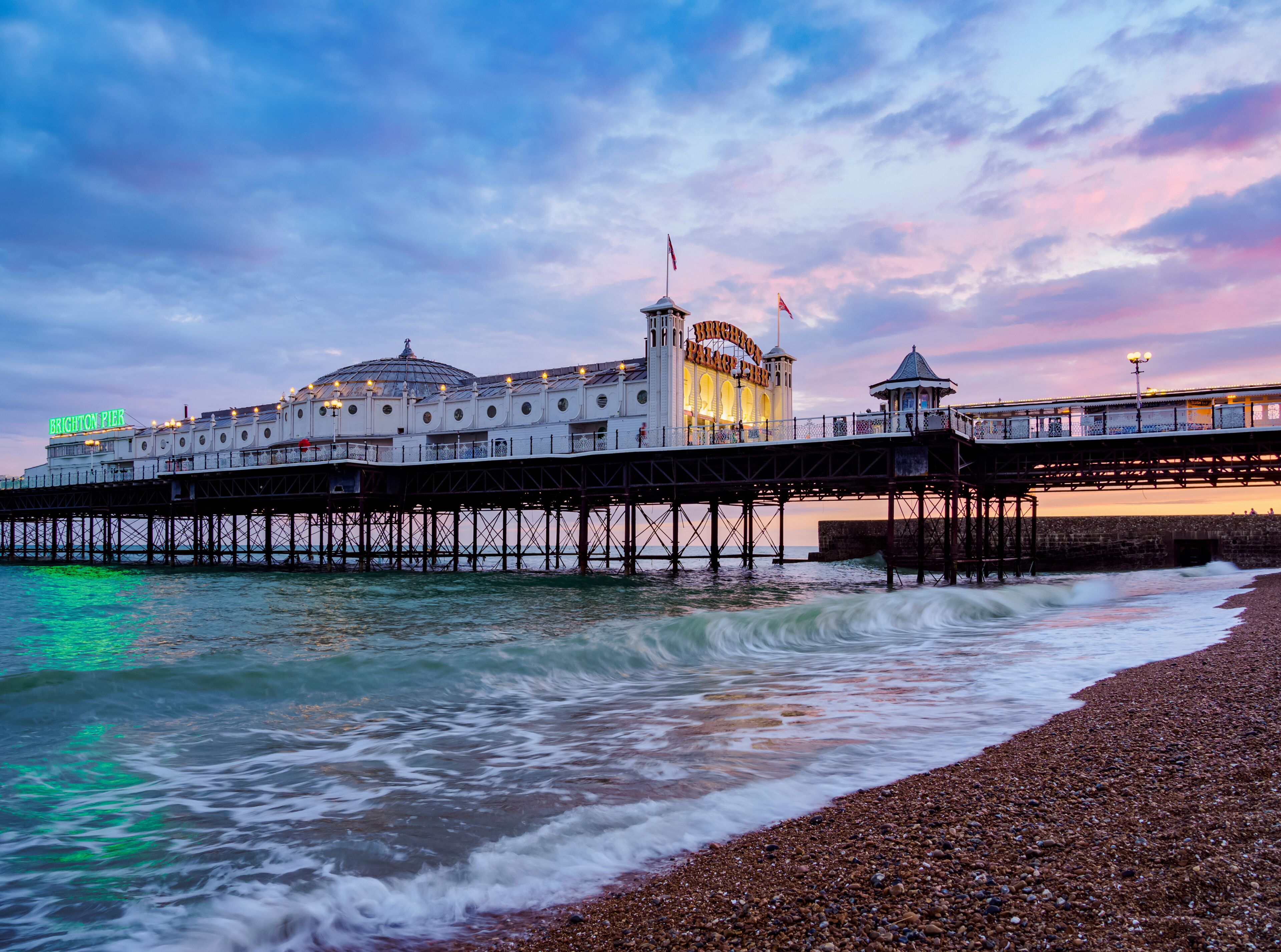 Brighton Pier with a pebbled beach and the sea.