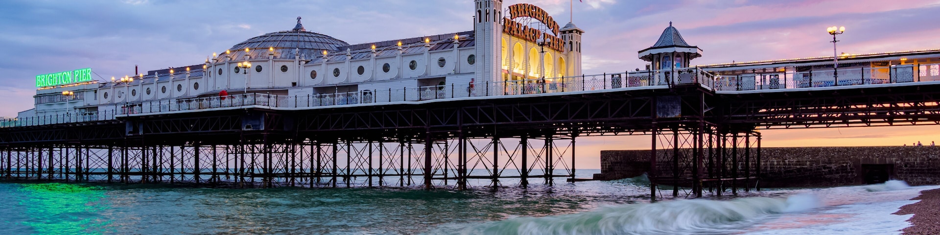 Brighton Pier with a pebbled beach and the sea.
