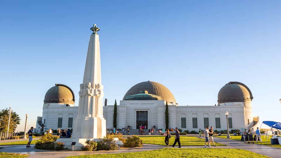 The Griffith Observatory with its distinctive domes and a tall monument.