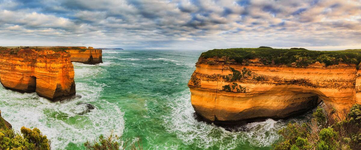 A coastal landscape with prominent cliffs and a turbulent sea.