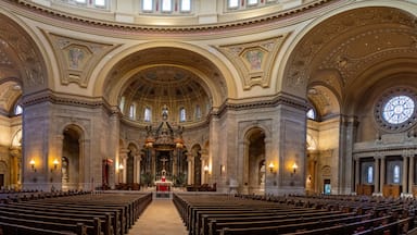 Interior de igreja ornamentado com tetos altos, arcos detalhados e vitrais.
