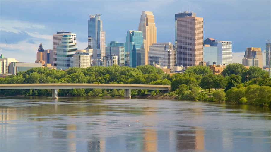 Une vue sur les toits d’une ville, avec des gratte-ciel modernes et un pont enjambant une rivière.