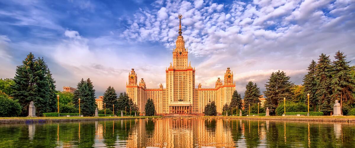 Neoclassical Moscow State University (MGU) building on Vorobyevy Gory, reflecting in lake, Russia