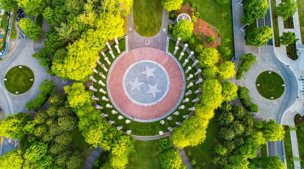 An aerial view of a circular plaza with a central star-patterned design, surrounded by trees and pathways.