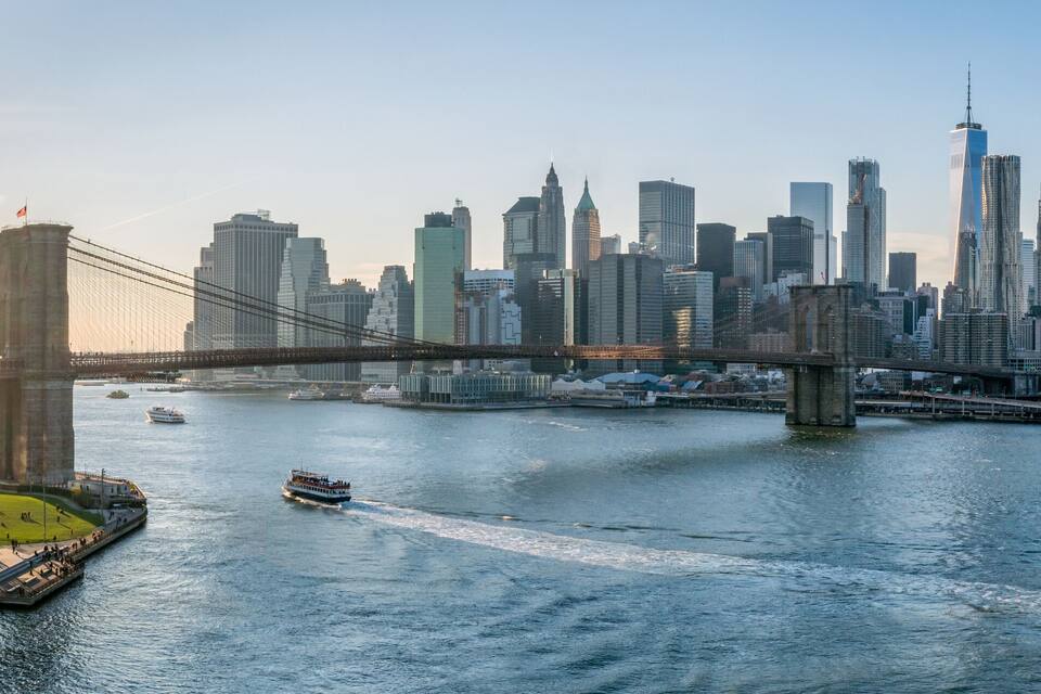 A river with a bridge and a city skyline in the background.