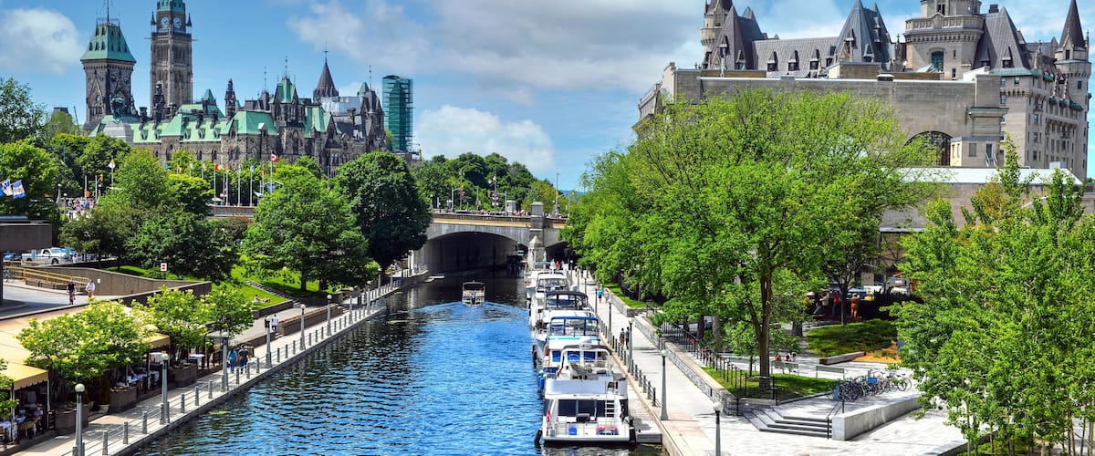A river with boats, a bridge, and historic buildings with spires.