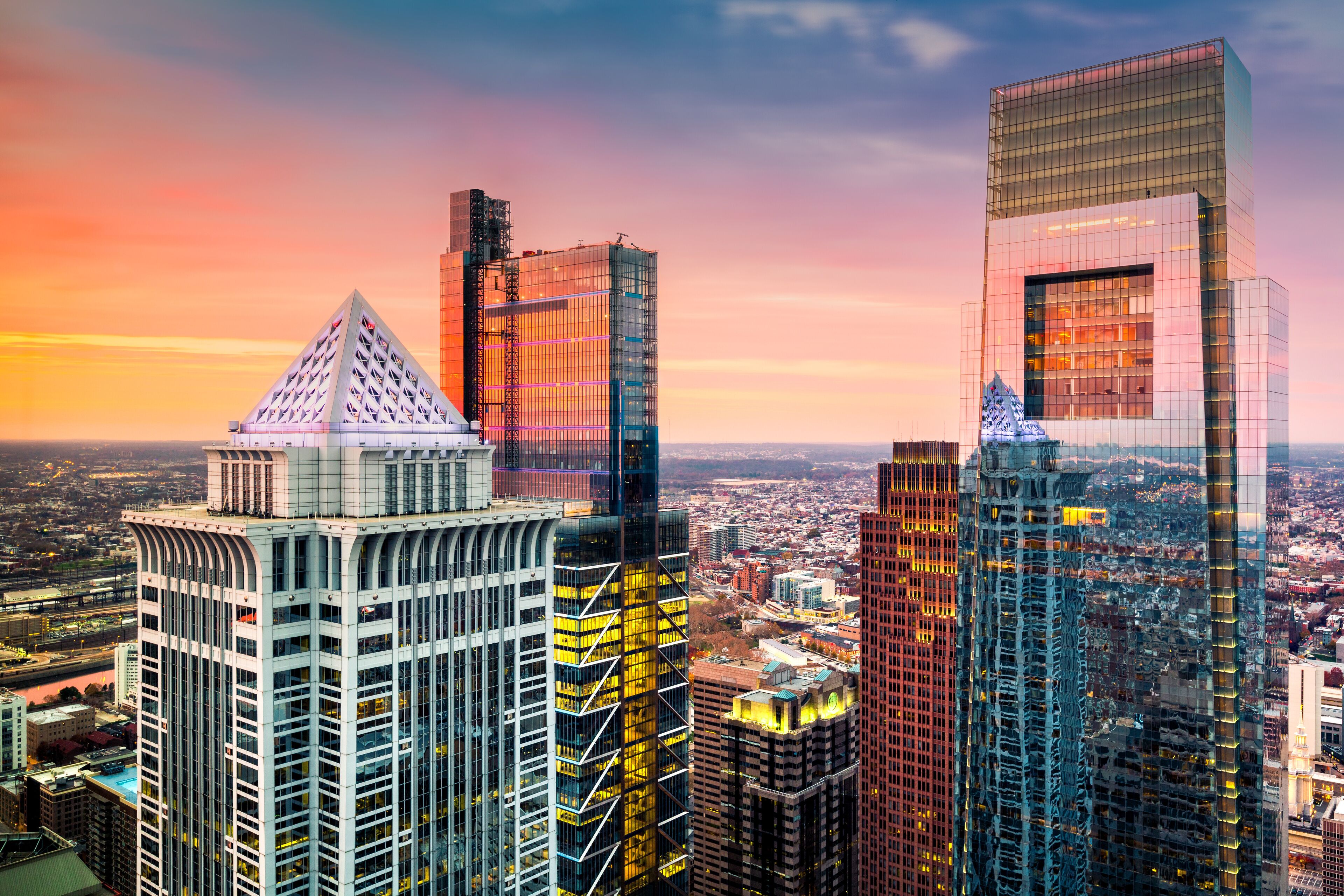 Philadelphia aerial with downtown skyscrapers at sunset.