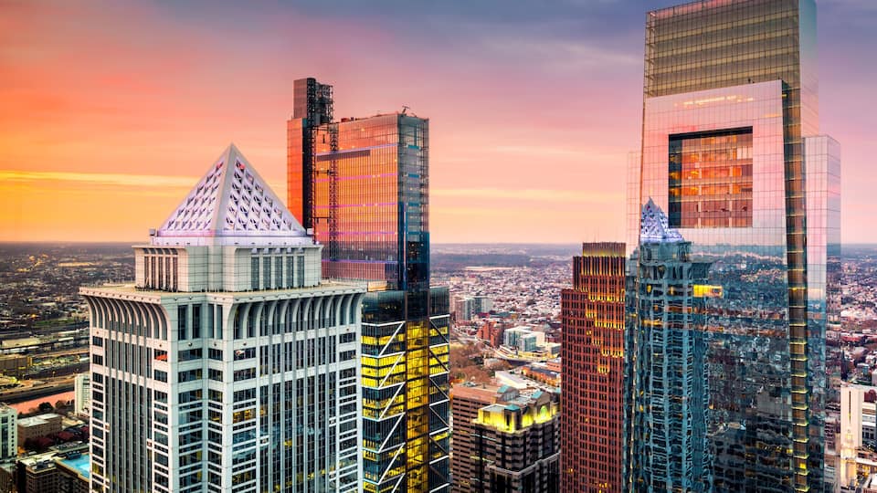 A cityscape with modern skyscrapers and a distinctive pyramid-shaped building.