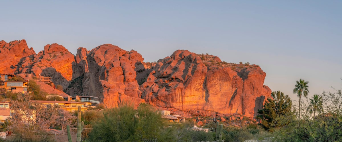 Una cordillera rocosa con casas modernas a su base.