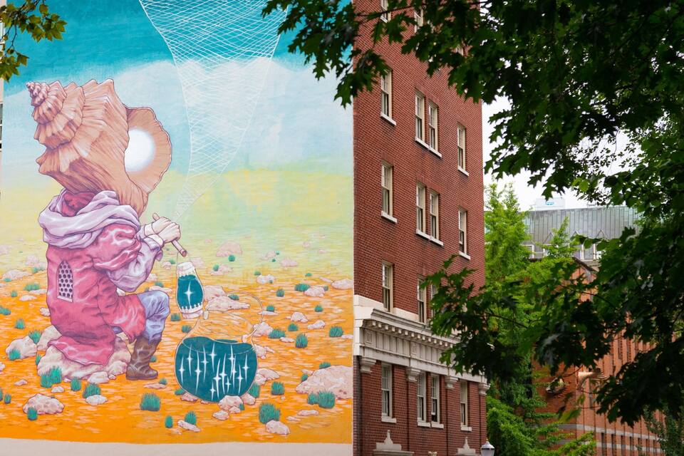 Un mural de un oso sosteniendo un escudo en una pared de edificio.