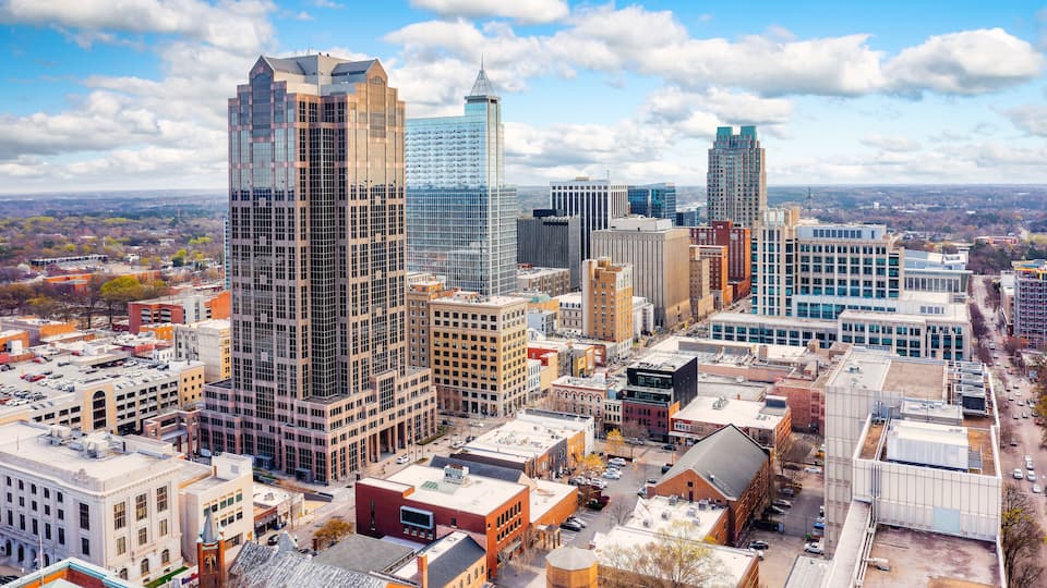 A cityscape with tall buildings, a mix of modern and older architecture, and a clear sky.