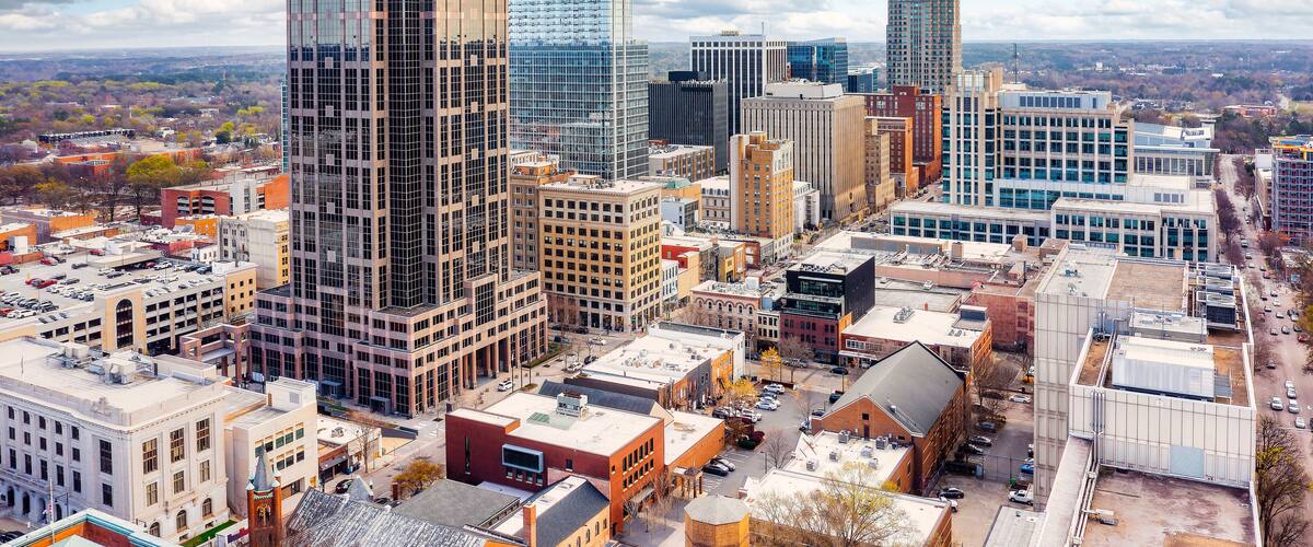A cityscape with tall buildings, a mix of modern and older architecture, and a clear sky.
