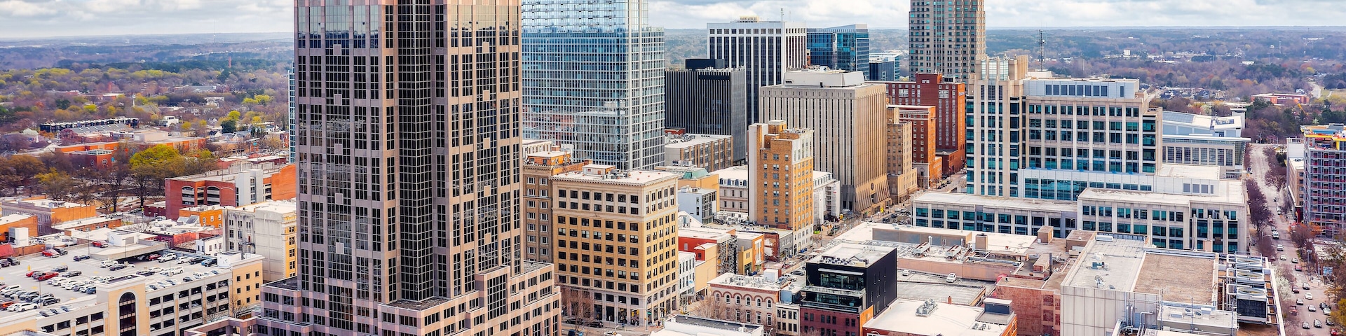 A cityscape with tall buildings, a mix of modern and older architecture, and a clear sky.