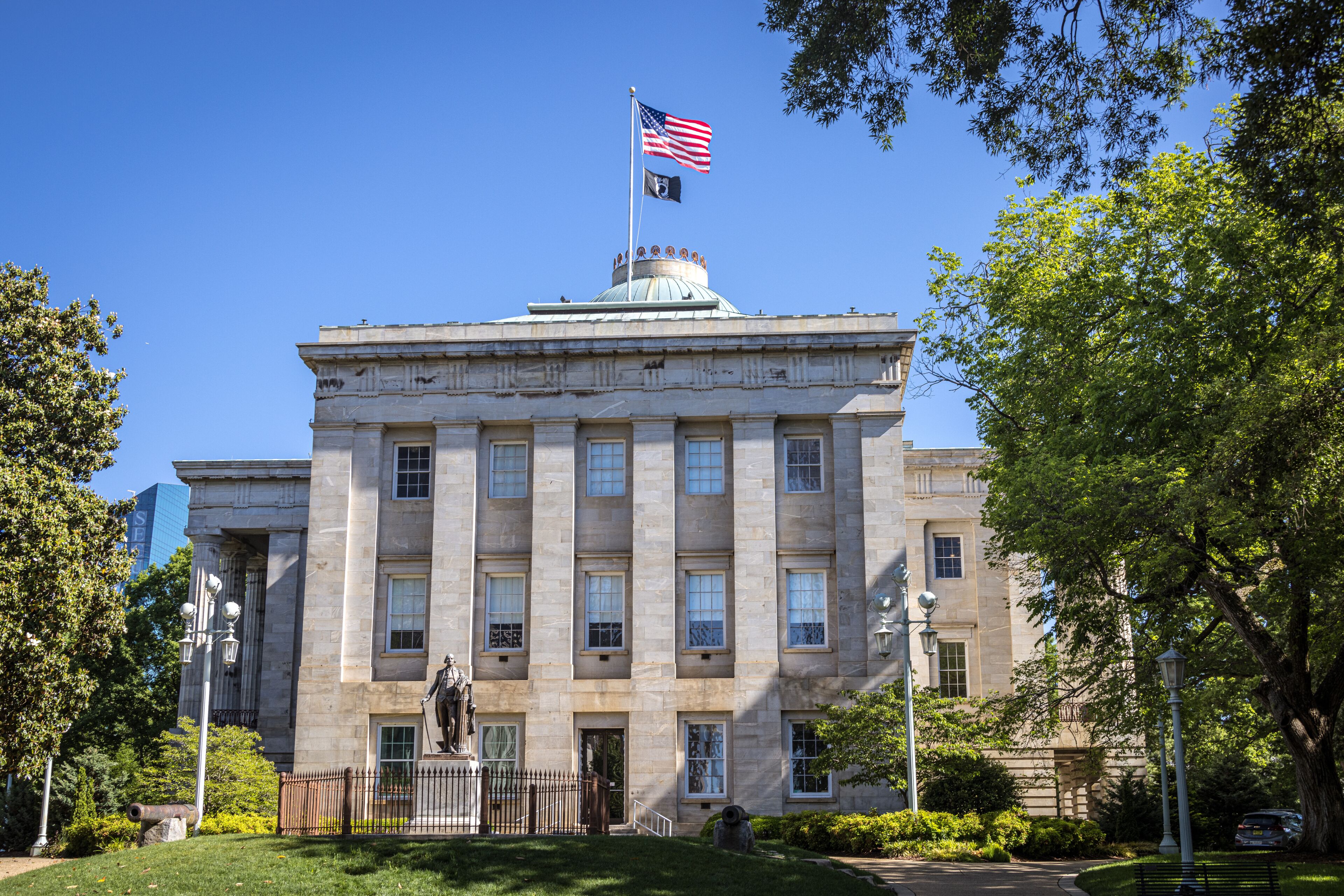 A large stone building with a dome and an American flag on top.
