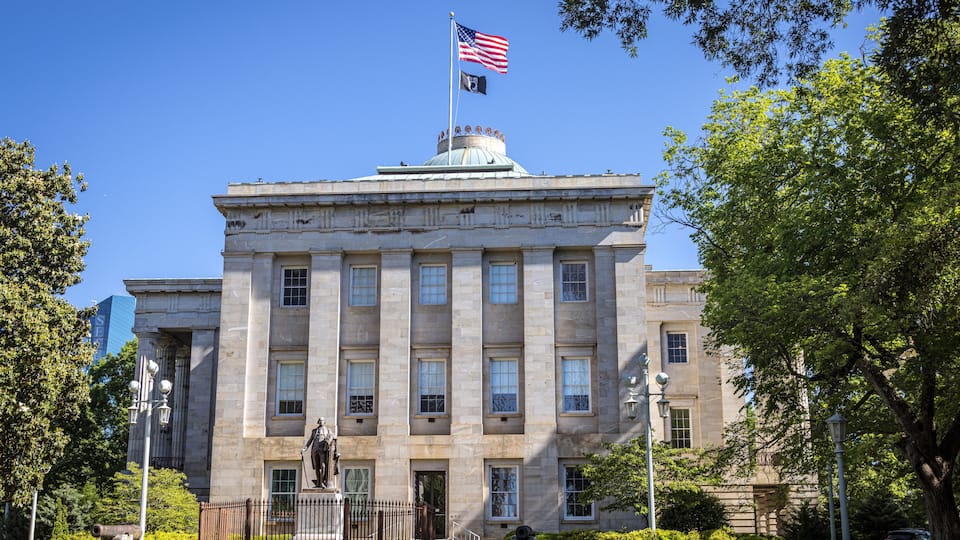 A large stone building with a dome and an American flag on top.