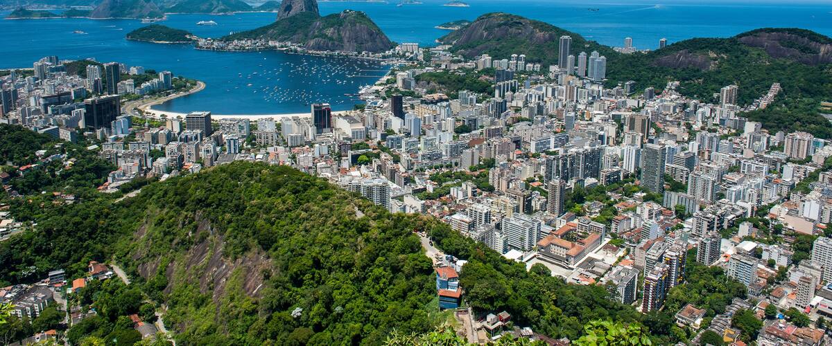 A coastal cityscape with a prominent mountain and a bay.