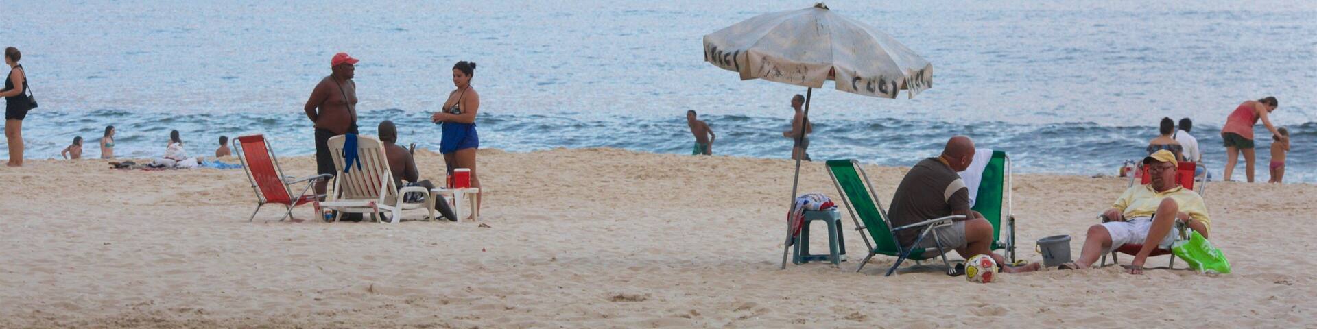 Rio de Janeiro featuring general coastal views and a sandy beach as well as a large group of people