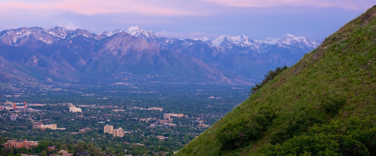 A mountainous landscape with snow-capped peaks and a valley with buildings.