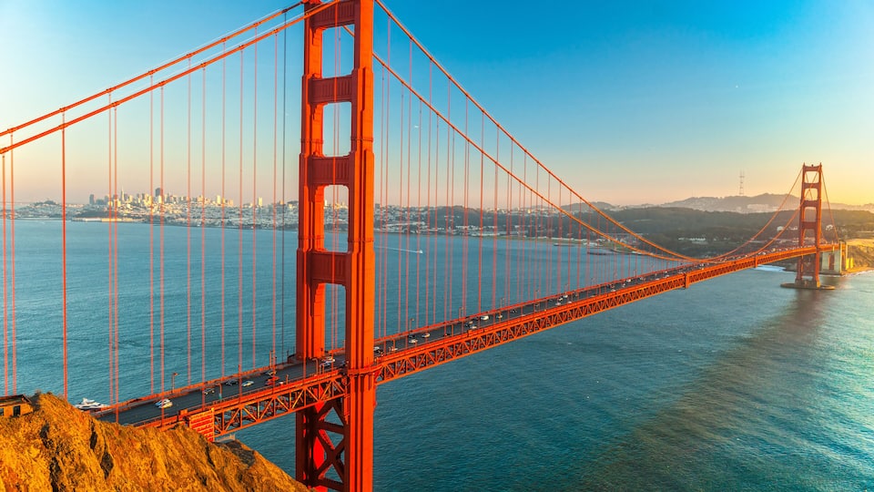 The Golden Gate Bridge spanning the San Francisco Bay with a city skyline in the background.
