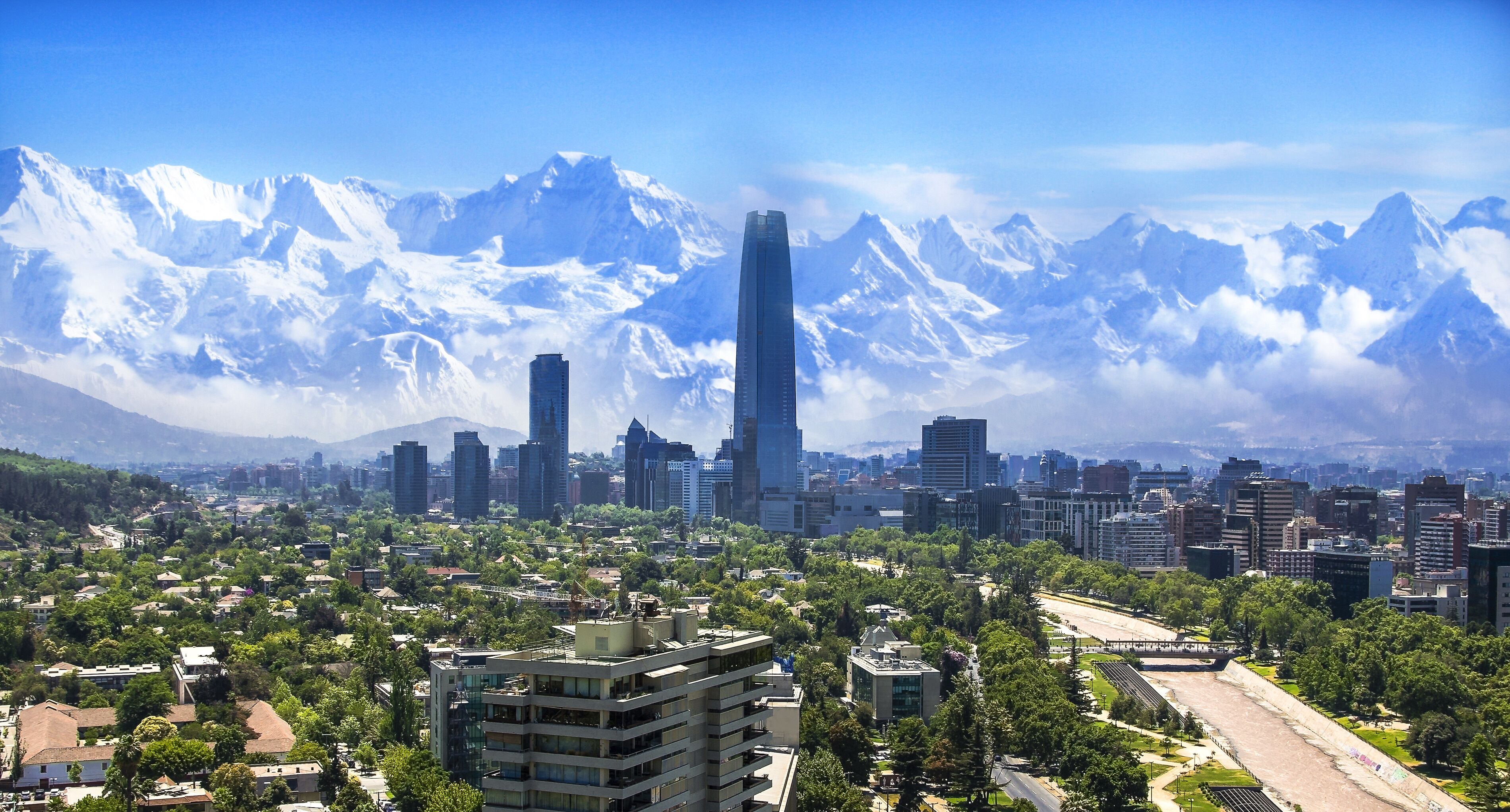 A cityscape with modern skyscrapers and a mountainous backdrop.