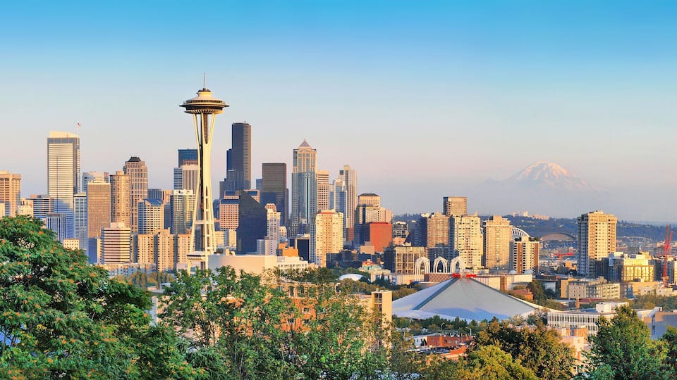 A city skyline with the Space Needle and a mountain in the background.