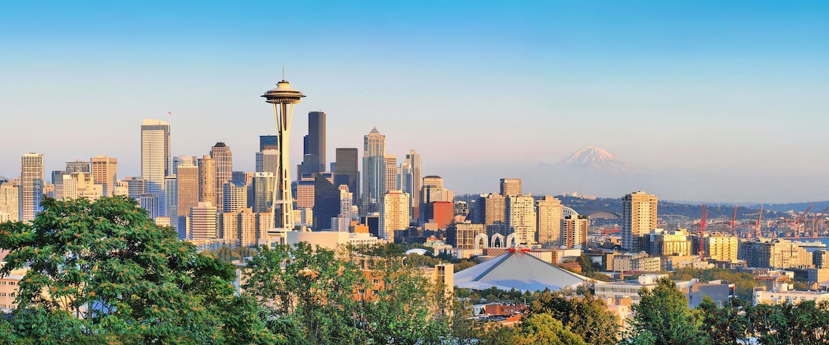 A city skyline with the Space Needle and a mountain in the background.