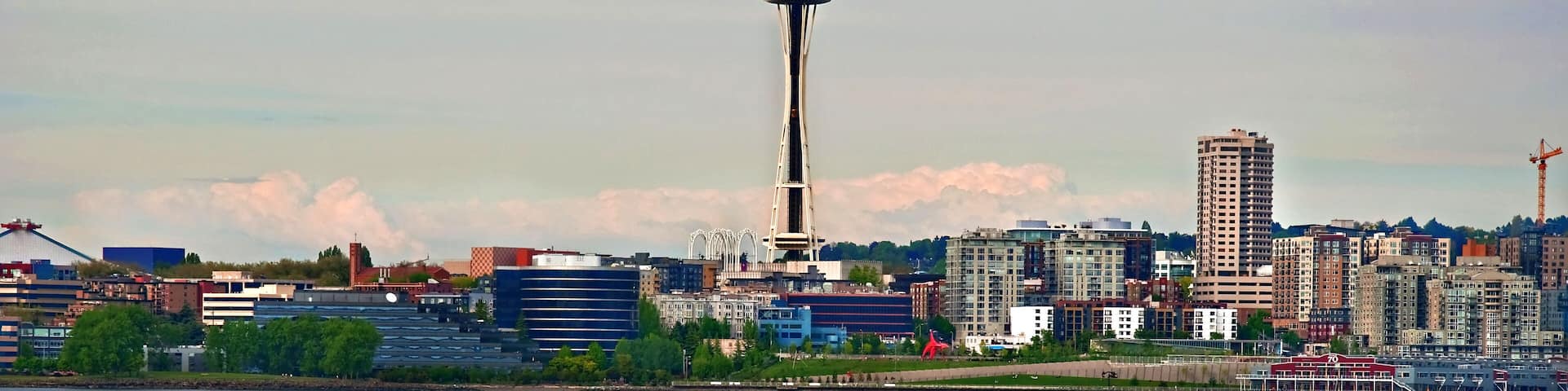 A city skyline with a prominent tower, a body of water, and a speedboat.
