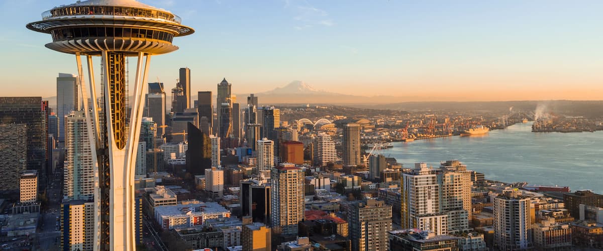 A cityscape with a prominent tower, a river, and a mountain in the background.