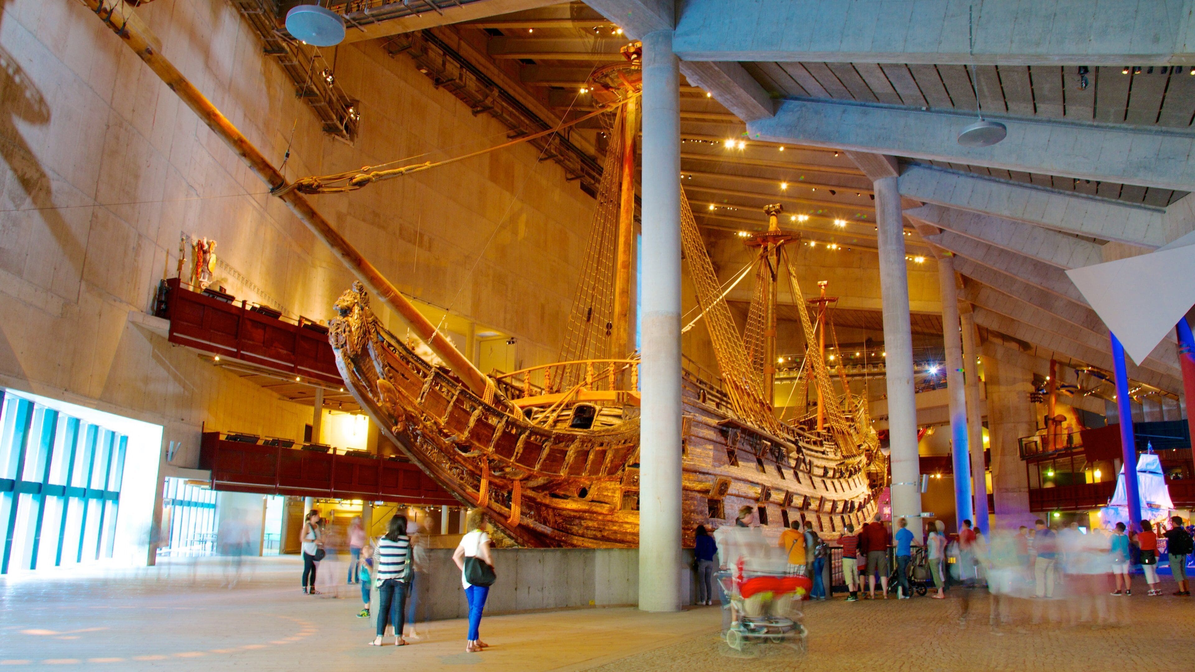 A large indoor ship model in a museum with visitors around it.