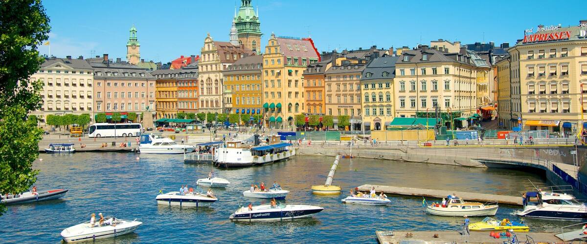 A harbor with boats, a church spire, and colorful buildings.