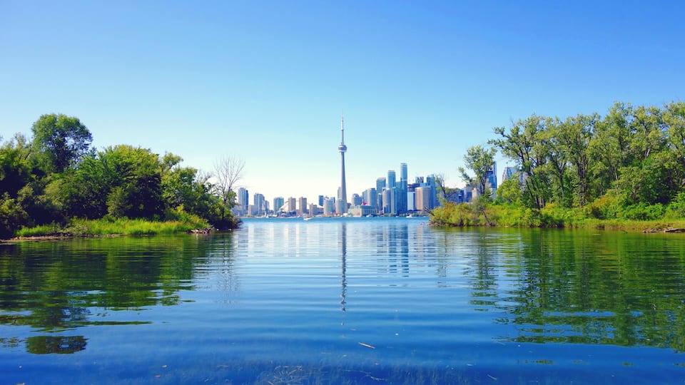 A river with a city skyline in the background, including a prominent tower.