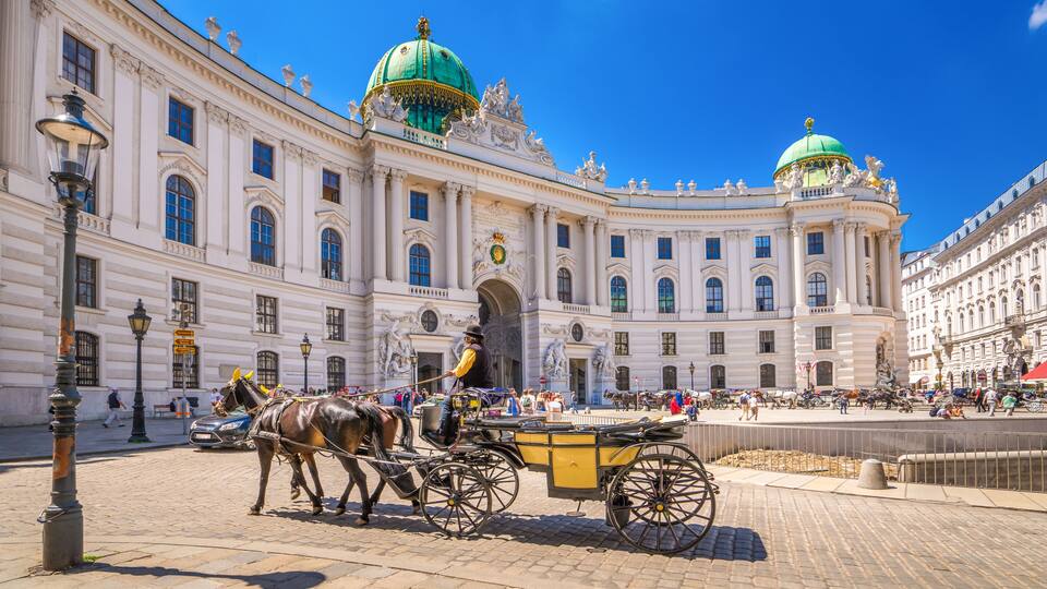 A historic building with ornate architecture and green domes.